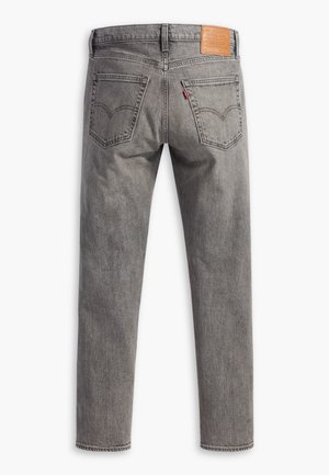 Jean en denim gris vu de dos avec deux poches, des passants de ceinture et une étiquette en cuir sur la ceinture.