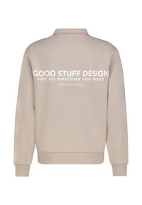 Beige Sweatshirt mit langen Ärmeln, gerippten Bündchen und Saum, mit großem weißen Text auf dem Rücken: "GOOD STUFF DESIGN MACH EINFACH, WAS DU WILLST."