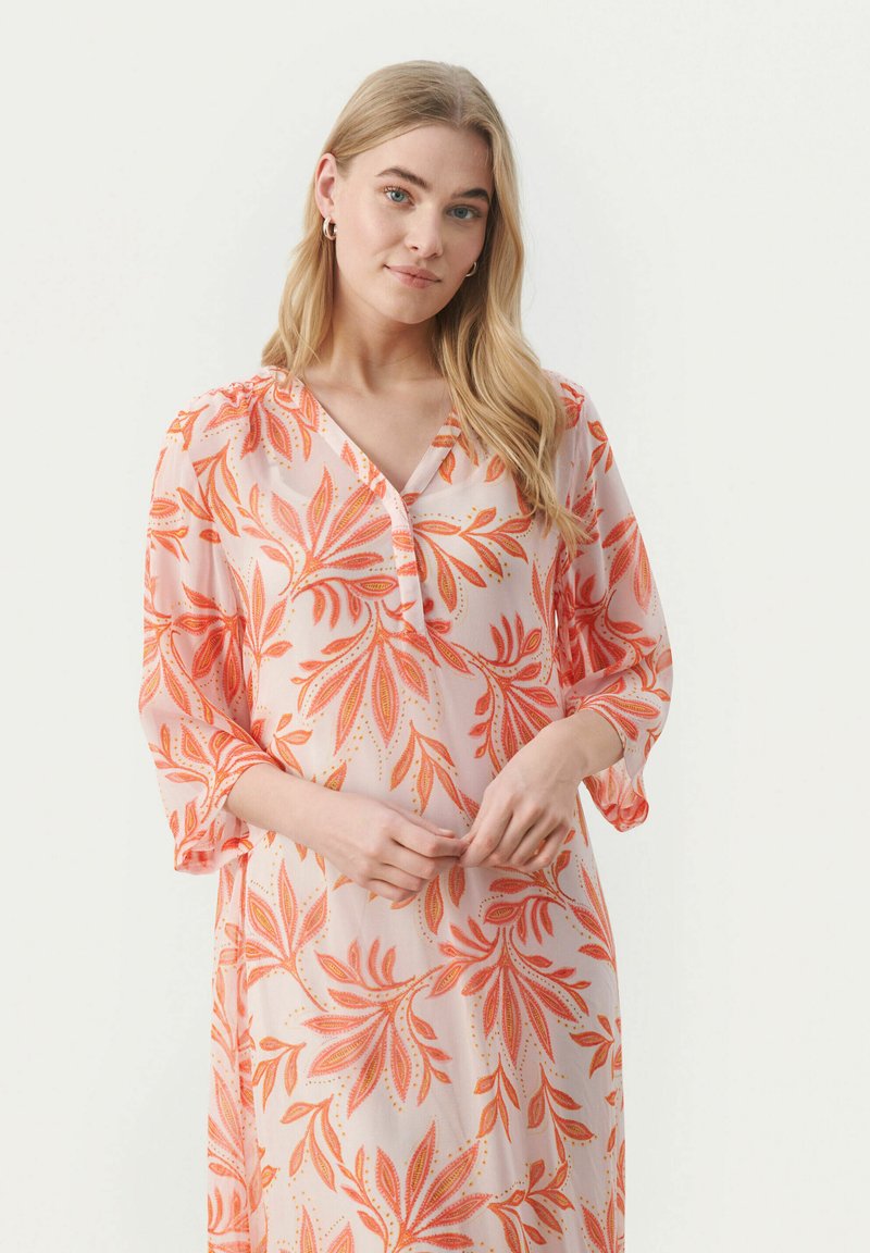 Robe florale en tissu transparent, avec une base rose et des motifs de feuilles orange, décolleté en V et manches trois-quarts. Design léger et fluide.