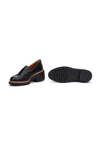 Mocasines de plataforma de cuero negro con punta redonda, costuras decorativas y suela de goma con dibujo. Presentan un acento en tono marrón claro.