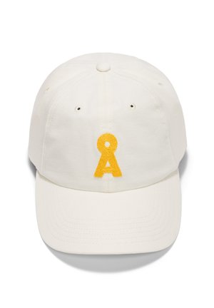 Cappello di cotone bianco con visiera curva, caratterizzato da una lettera "A" ricamata in giallo sulla parte anteriore e fori di ventilazione ai lati.