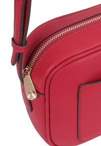 Rode leren schoudertas met een gouden rits, platte voorkant en contrasterende stiksels langs de randen. Soepel, textuur oppervlak.