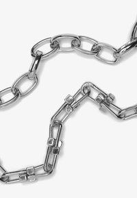 Silver metal chain featuring interlocking oval and rectangular links, with textured square accents. Smooth surface and shiny finish.