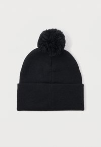 Melna adīta ziemas cepure ar lielu pom-pomu uz augšu un salocītu maliņu, izklāta uz baltā fona.