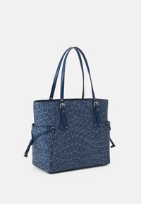 Sac fourre-tout bleu en tissu à motifs avec un design Monogram. Il dispose de deux poignées robustes, d'une fermeture zippée et de quincaillerie décorative.