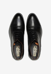 Zapatos de vestir de cuero negro con un diseño elegante, punta redondeada y cordones. Presentan un suave forro interior y plantilla de marca para mayor comodidad.