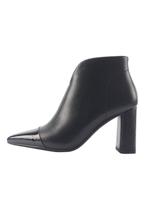 Botas de cuero negro de tobillo con punta afilada, acento de charol brillante y un tacón cuadrado de altura media. Textura suave y diseño elegante.