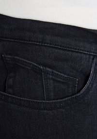 Los vaqueros de mezclilla oscura presentan un pequeño bolsillo trasero, costuras sutiles y una textura suave. El color es un azul marino profundo con un desvanecimiento mínimo.