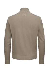 Beige gestrickter Pullover mit steilem Kragen, geripptem Saum und Bündchen, versehen mit einem kleinen Logo-Patch am Nacken. Sanfte Textur.