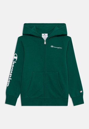 Zeleni dukserica s patentnim zatvaračem izrađena od mekanog materijala. Ima kapuljaču, prednje džepove i bijeli "Champion" logo na prsima i desnoj rukavu.