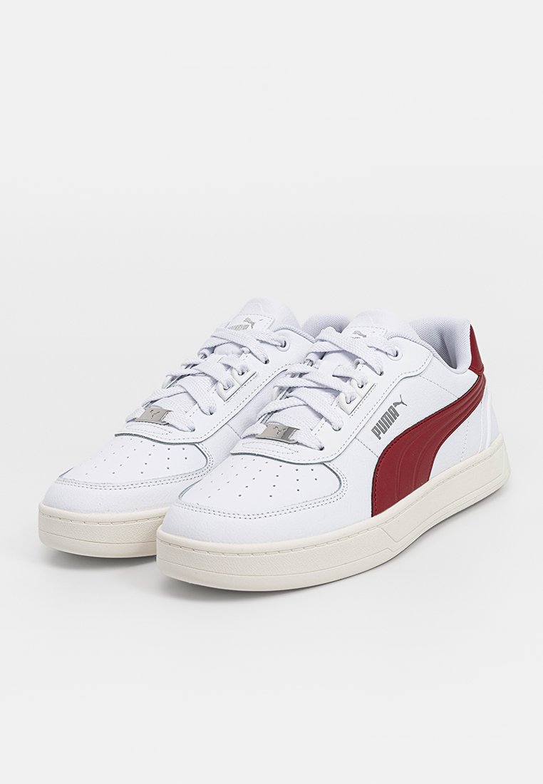 Baskets avec une tige synthétique blanche, ornées d'une bande latérale bordeaux, de détails perforés et d'une semelle en caoutchouc crème texturée.