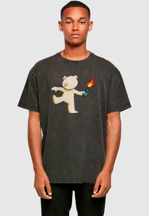 Sort oversized t-shirt lavet af blød bomuld, der har et farverigt bjørnedesign, som holder en flamme. Slidt tekstur med en rund udskæring.