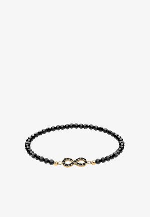 Bracelet noir en perles avec des perles facettées, agrémenté d'un accent en or en forme de symbole infini avec des détails noirs au centre.