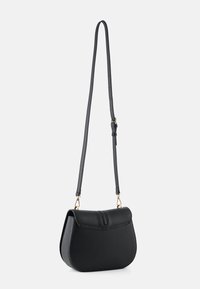 Black leather crossbody bag with a rounded shape, flat top flap, adjustable strap, and gold-tone hardware accents.