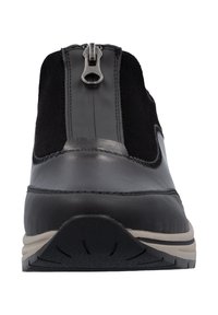 Bottines en cuir noir et en daim avec une fermeture éclair, présentant une semelle texturée et un discret détail de couture. Design à profil bas.
