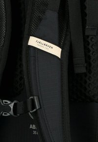Zaino Fjällräven nero con tasca in rete, spallacci regolabili e etichetta con logo rettangolare. Il materiale sembra resistente con una finitura testurizzata.