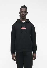 Μαύρο φούτερ με κουκούλα από βαμβακερό μείγμα, με μπροστινή τσέπη τύπου καγκουρό και κόκκινο λογότυπο "GUESS JEANS" στο στήθος.