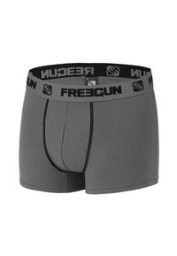 Boxers gris en tissu doux avec une ceinture élastique noire portant le logo "FREEGUN", une poche à l'avant et des détails de coutures contrastés.