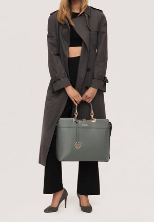 Graue Lederhandtasche mit einem strukturierten Design, goldfarbenen Beschlägen und einem Logo. Die Tasche verfügt über zwei obere Henkel und einen Anhänger als Akzent.