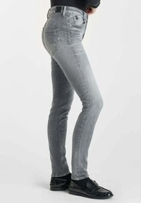 Jean skinny gris en denim, doté de cinq poches, d'une légère décoloration et d'une pièce en cuir noir sur la ceinture arrière.