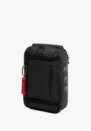 Zwarte rugzak gemaakt van duurzaam materiaal; rechthoekige vorm met zijrits, frontstrap en karabijnhaak bevestiging; heeft een rode label.