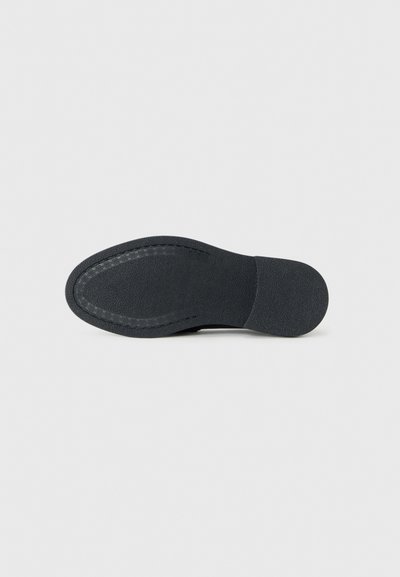 Black shoe sole with textured rubber surface, featuring a curved shape and a stitched border along the edge.