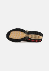 Sneaker outsole features a black rubber base, transparent yellow midsole, red round accents, and textured grip patterns for traction.