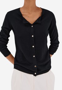 Černý cardigan z měkké tkaniny s výstřihem do V, dlouhými rukávy a zaoblenými kovovými knoflíky po přední straně.