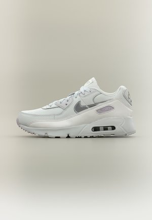 Baskets Nike Air Max blanches et grises vues de côté, montrant les lacets, la tige en mesh et l'amorti à air visible dans la semelle.