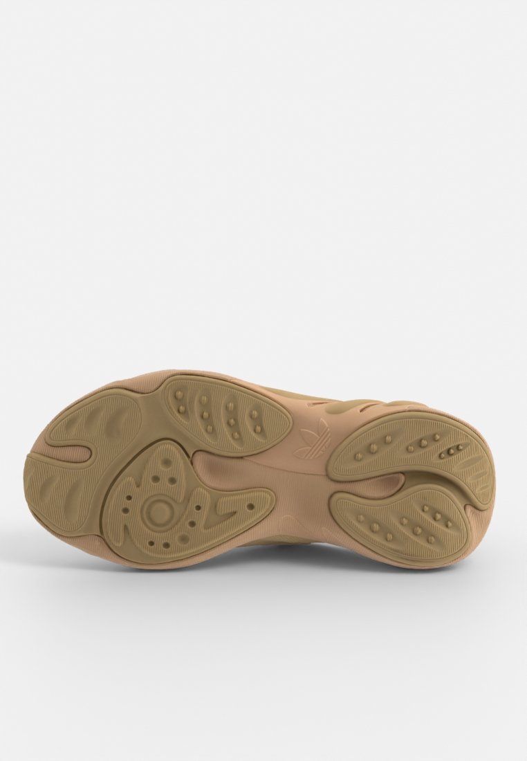 Sole in gomma beige, con texture di motivi circolari e ovali per una migliore aderenza. Presenta un logo e un design di battistrada distintivo lungo i bordi.