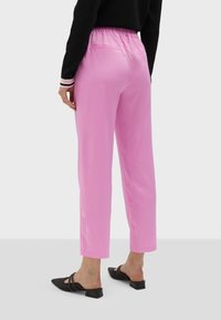 Lila, lätta byxor med elastisk midja och rak benpassform samt två bakfickor. Kombinerat med svarta spetsiga mules.