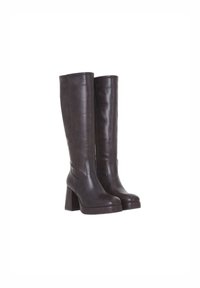 Une paire de bottes en cuir marron foncé, hautes, avec des talons épais et des bouts ronds, se tenant droites sur un fond blanc.