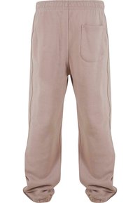 Pantaloni de trening bej cu talie elastică, croi lejer și un singur buzunar pe spate. Textură moale cu detalii subtile pe latură.