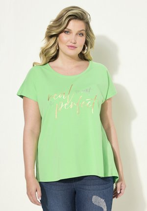 Green short-sleeve t-shirt made of soft fabric; features metallic print with the words "real not perfect" in gold and purple.