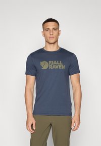 Námornícky krátky rukáv tričko z mäkkého materiálu s veľkým olivovo zeleným logom "FJÄLL RÄVEN" a štítkom s logom prišitém na boku.