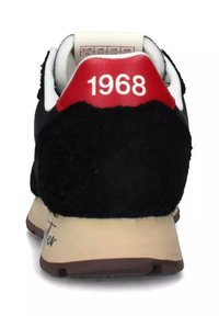 Sneaker nera con finitura testurizzata, accentata da un tallone rosso con "1968" e una suola beige. Presenta bordi bianchi e un colletto imbottito.
