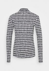 Svart och vit hundtandsmönstrad långärmad skjorta som sitter tight med krage och slätt tyg.