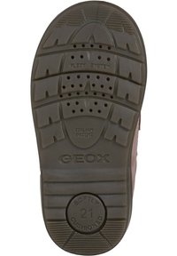 Suela de zapato de goma marrón con patrón de textura en la superficie, respiraderos y marca en relieve. Incluye características de acolchado y diseño flexible.
