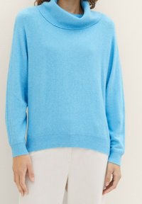 Ljust blå cowl-neck tröja gjord av mjukt, strukturerat tyg. Har långa ärmar och ribbade muddar och fåll för en bekväm passform.