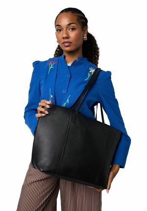 Bolso tote de cuero negro con textura suave, forma rectangular y correas largas. Presenta un diseño minimalista sin adornos.
