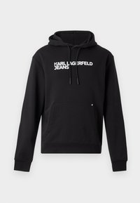 Čierna mikina s kapucňou vyrobená z mäkkého materiálu, s klokankou a kapucňou s šnúrkou. Na hrudi je biele potlačené "KARL LAGERFELD JEANS".