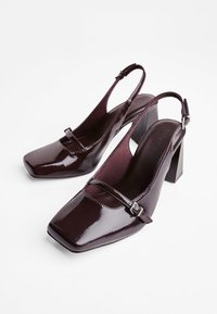 Bordeaux-lakatut nahka slingback-korkokengät suorilla varpailla, etuosassa oleva hihna ja tukevat suorakulmaiset korot.
