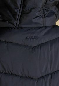 Granatowa kurtka puchowa z chevronowym pikowaniem, gładką teksturą i haftowanym logo "JOULES". Zaprojektowana z myślą o ciepłej i wygodnej noszeniu.