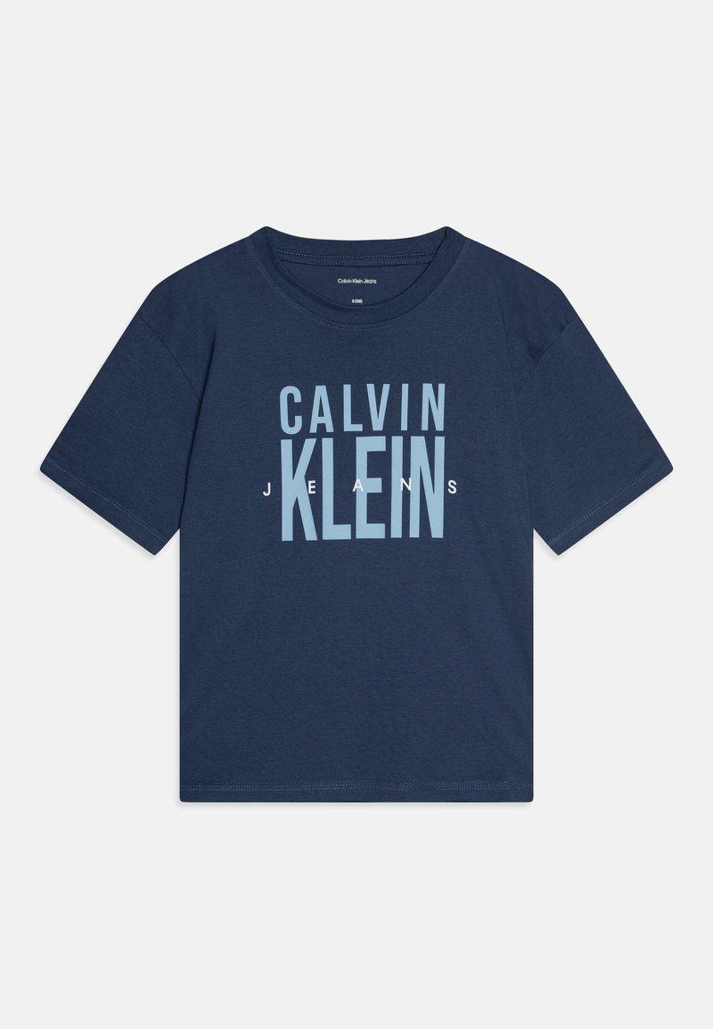 Camiseta de algodón azul marino con manga corta, que presenta texto blanco que dice "CALVIN KLEIN JEANS" en una fuente en negrita en la parte delantera.