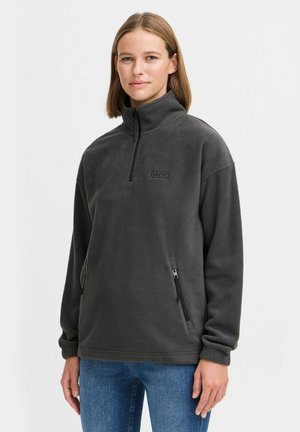 Donkergrijze fleece pullover met een hoge kraag, rits aan de voorkant en zijzakken. Bevat een klein logo op de borst en geribde manchetten.