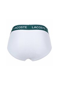 Witte katoenen slip met een groene elastische tailleband waarop het "LACOSTE" logo in het wit is gedrukt. Gladde textuur en aansluitend ontwerp.