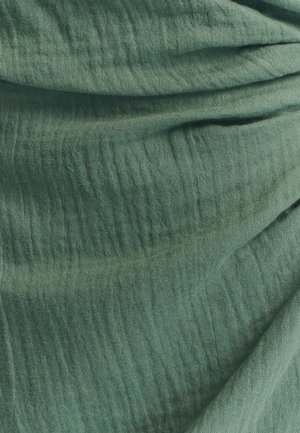 Groen gestructureerd stof met een gekreukeld uiterlijk, met een zacht, lichtgewicht materiaal en een subtiel, oneffen patroon.