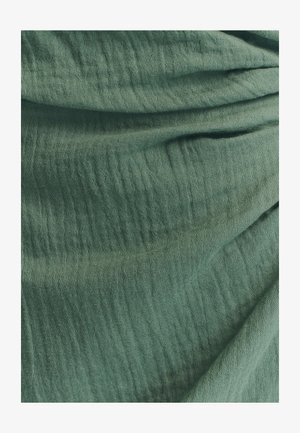 Groen gestructureerd stof met een gekreukeld uiterlijk, met een zacht, lichtgewicht materiaal en een subtiel, oneffen patroon.