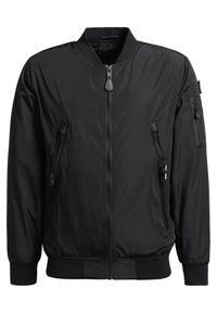 Veste bomber noire avec fermeture éclair centrale, deux poches latérales zippées, col, poignets et ourlet côtelés, ainsi qu'une poche zippée sur la manche gauche.
