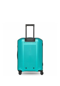 Valise rigide turquoise avec des rainures verticales, quatre roues noires et une poignée télescopique noire étendue, debout en position verticale.